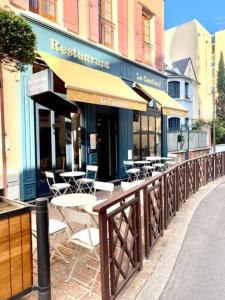 um restaurante com mesas e cadeiras em frente a um edifício em Studio Exotique Hyper-Centre Enghien 12min Paris em Enghien-les-Bains