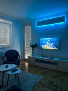 un soggiorno con TV e soffitto blu di Apartman ML a Lukavica