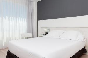 Łóżko lub łóżka w pokoju w obiekcie Axor Feria