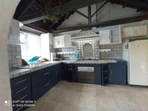 een keuken met blauwe kasten en een witte koelkast bij ARCOS DE LA LOMA in Paipa