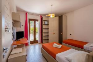 Zimmer mit 2 Betten, einem Schreibtisch und einem TV in der Unterkunft Perla Salentina in Taviano