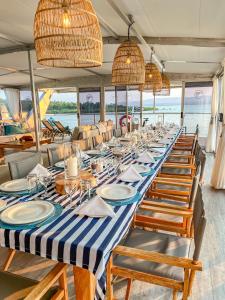 a long table with chairs and plates on a boat at Shayamanzi Houseboats in Jozini
