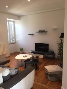 a living room with a couch and a table at MONTALIEU SEJOUR Appartement les orchidées, 4 pers in Montalieu-Vercieu