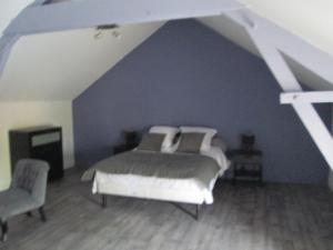 a bedroom with a bed and a blue wall at La Ferme de la Petite Noé in Tracy-sur-Mer