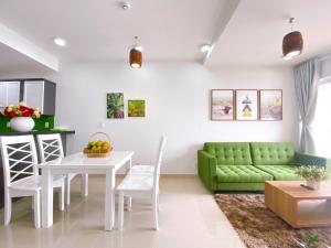 a living room with a green couch and a table at Nice Apartment Oasky Vũng Tàu 1805 in Vung Tau
