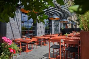 un restaurante con mesas de madera, sillas y flores en Malmaison Dundee en Dundee