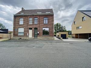 an empty parking lot in front of a brick building at Riversight in Les Deux-Acren