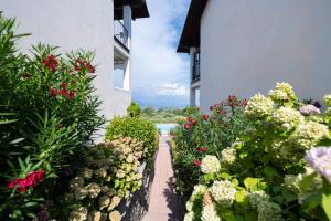a garden of flowers in front of a building at Appartamento Katy in Polpenazze del Garda