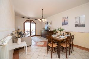 a dining room and living room with a table and chairs at Appartamento Katy in Polpenazze del Garda