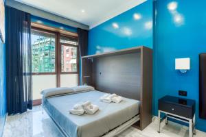 una camera da letto con pareti blu e un letto con asciugamani di AR ROOMS ROME a Roma