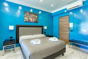 una camera blu con un letto e asciugamani di AR ROOMS ROME a Roma