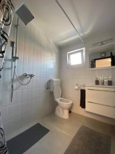 a white bathroom with a toilet and a window at Korona Apartman Balatonboglár in Balatonboglár