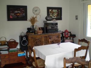 a dining room with a table and a clock on the wall at Hotel L'Ablana in Pola de Somiedo