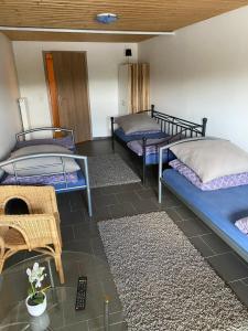 a room with three bunk beds and a chair at Haus Erlenweg in Neuenkirchen-Vörden