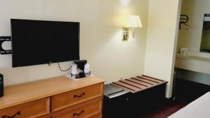 TV de pantalla plana en la pared de una habitación de hotel en Americas Best Value Inn & Suites Melbourne en Melbourne