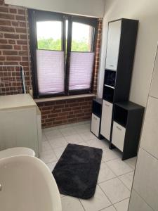 a bathroom with a sink and a refrigerator at Haus Erlenweg in Neuenkirchen-Vörden