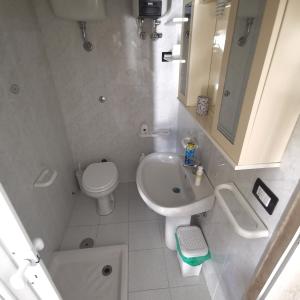 bagno bianco con lavandino e servizi igienici di The tower a Capurso
