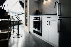 uma cozinha com armários brancos e um fogão em Les diamants de l'éternel em Saint-David-de-Falardeau