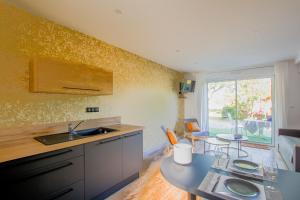 a kitchen with a sink and a table at La Bohal' Loire in La Bohalle