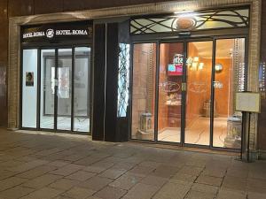 a store front with glass doors on a building at Hotel Roma in Bologna