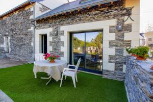 eine Terrasse mit einem Tisch und Stühlen auf dem Rasen in der Unterkunft La Bohal' Loire in La Bohalle