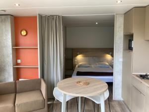 ein Schlafzimmer mit einem Bett und einem Tisch in einem Zimmer in der Unterkunft Cottage 2 pers KEY WEST Premium in Hourtin