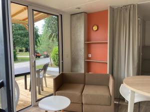 a living room with a couch and a table at Cottage 2 pers KEY WEST Premium in Hourtin