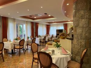 a restaurant with tables and chairs and a stone wall at Boutique Hotel Grahor in Sežana