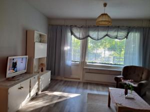 - un salon avec une télévision et une grande fenêtre dans l'établissement Kemiön saari, à Kemiönsaari