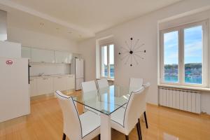 una sala da pranzo con tavolo in vetro e sedie bianche di Eden Penthouse Apartments a Zara (Zadar)