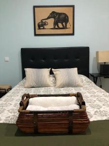 Una cama con una cesta con una foto de un elefante en APARTAMENTO PRIVADO CERCA DE IFEMA y AEROPUERTO, en Madrid