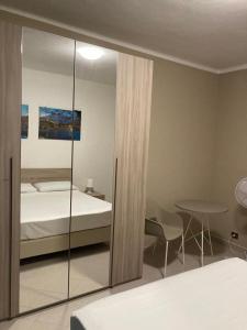 - une chambre avec un lit, une table et un miroir dans l'établissement Apartment "Borgo Olivetti", à Ivrea