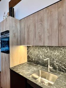 a kitchen with a sink and wooden cabinets at Saas-Fee renovated flat in center of the village in Saas-Fee