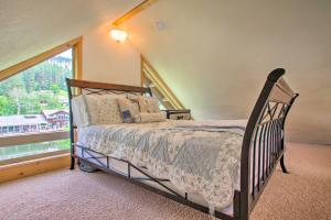 a bedroom with a bed and a large window at Waterfront Cabin with 2 Boat Docks and Mtn Views! in Saint Maries