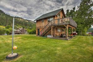 a large wooden house with a ball on the grass at Waterfront Cabin with 2 Boat Docks and Mtn Views! in Saint Maries