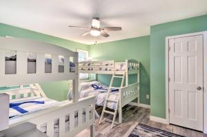 a room with two bunk beds and a ceiling fan at Sunrise Beach Home with Boat Dock on the Ozarks in Sunrise Beach