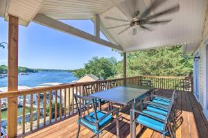 a deck with a table and chairs and a ceiling fan at Sunrise Beach Home with Boat Dock on the Ozarks in Sunrise Beach