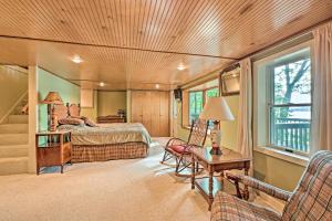 a bedroom with a bed and a chair and a table at Le Roy Lakefront Retreat with Dock and Kayaks! in Le Roy