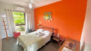 a bedroom with an orange wall and a bed at Bougainville - Hotel Pousada-Zen in Salvador +104 photos