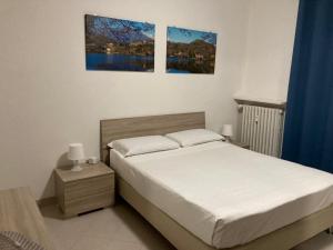 een slaapkamer met een bed en twee foto's aan de muur bij Apartment "Borgo Olivetti" in Ivrea