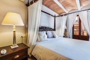 a bedroom with a bed with a lamp and curtains at Ca´n Pere in Alcudia