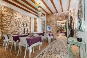 a dining room with tables and chairs and a stone wall at Ca´n Pere in Alcudia