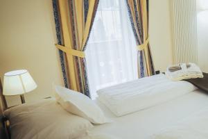1 dormitorio con 1 cama y ventana en Hotel Al Parco, en Moena