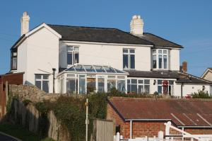 a large white house with a conservatory at The Patch in Hill Head