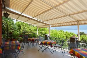 een patio met tafels en stoelen onder een pergola bij My Holidays - Camere dei Fiori in Gravedona