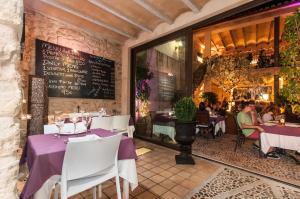 a restaurant with purple tables and people sitting at tables at Ca´n Pere in Alcudia