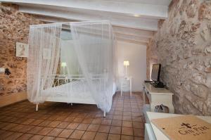 a bedroom with a bed with a mosquito net at Ca´n Pere in Alcudia