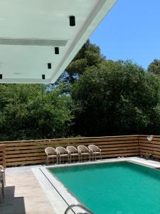 uma piscina com cadeiras ao lado de uma cerca de madeira em Adria Hotel em Golem