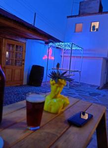 ein Glas Bier auf einem Holztisch in der Unterkunft Casa Valentino Trattoria & Alojamiento in Mineral del Monte