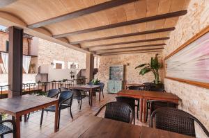 a restaurant with tables and chairs and a brick wall at Ca´n Pere in Alcudia
